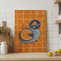 Placa Decorativa Estilo Pintura Mid Century Composição de Torta e Frutas em Pratos Azuis sobre Fundo Xadrez Laranja
